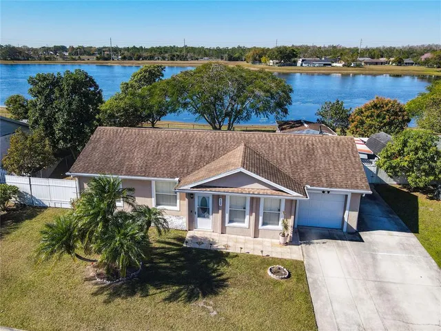 an aerial view of a house with outdoor space and lake view