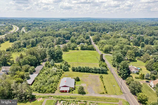 an aerial view of a residential houses with outdoor space and trees