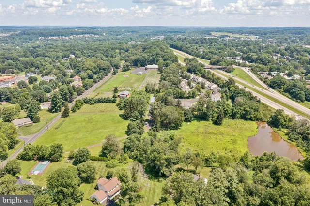an aerial view of residential houses with outdoor space and trees all around