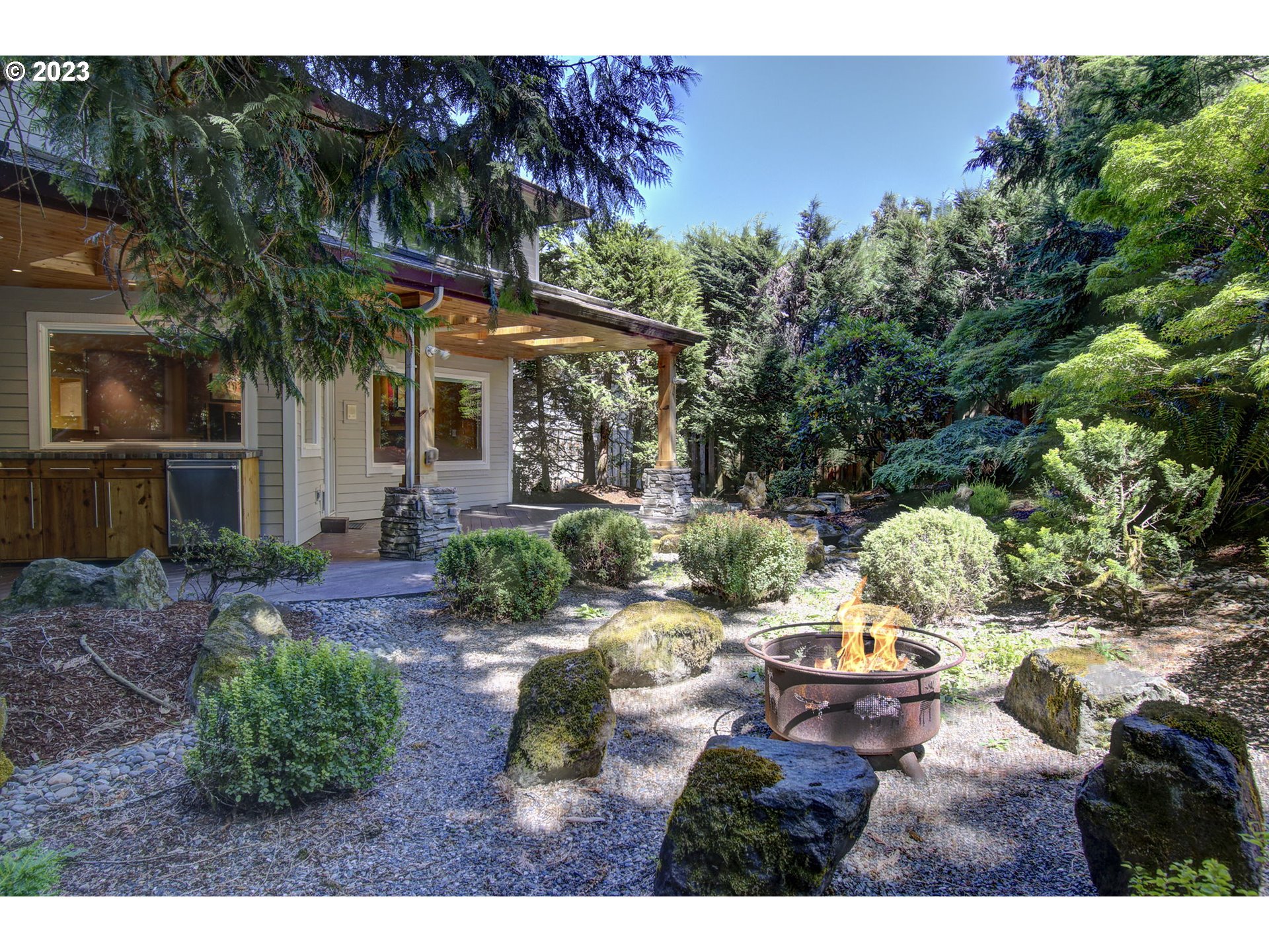2407 Northeast 165th Street Ridgefield, WA 98642 - Photo 33 of 46 a view of a backyard with table and chairs potted plants and large tree