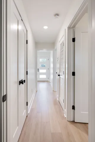 a view of a hallway with wooden floor