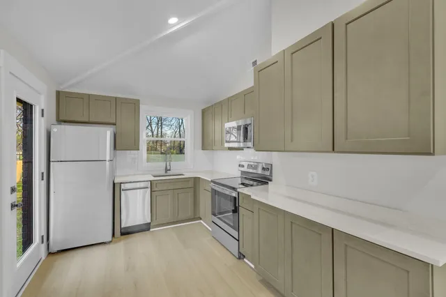 a kitchen with a sink a refrigerator and cabinets