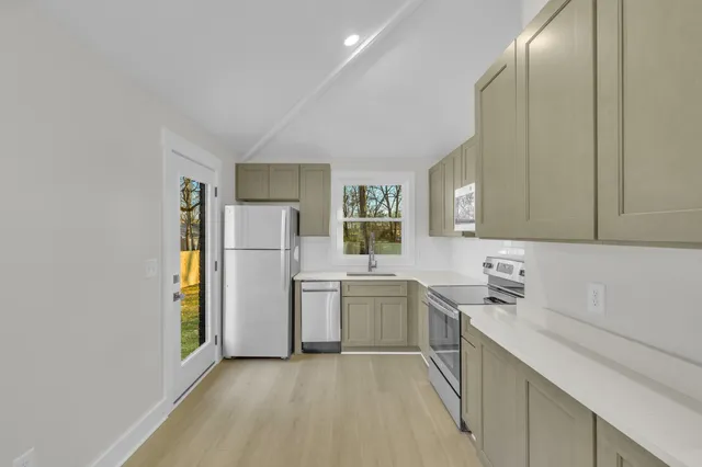 a kitchen with a sink a refrigerator and cabinets
