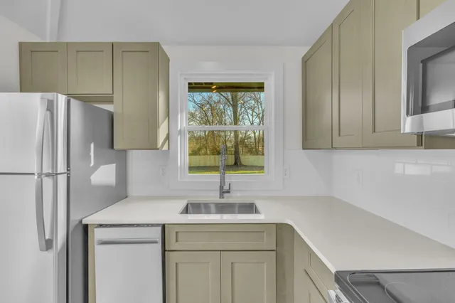 a kitchen with a refrigerator sink and cabinets