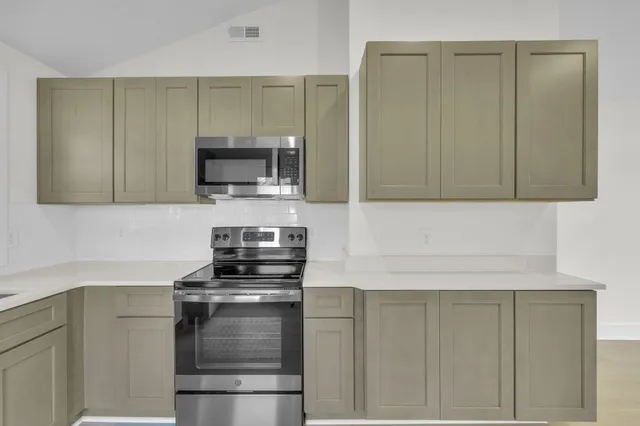 a kitchen with kitchen island a sink stove and microwave