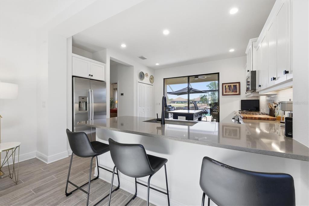 216 Brienza Loop Nokomis, FL 34275 - Photo 13 of 58 a kitchen with stainless steel appliances kitchen island granite countertop a table and chairs
