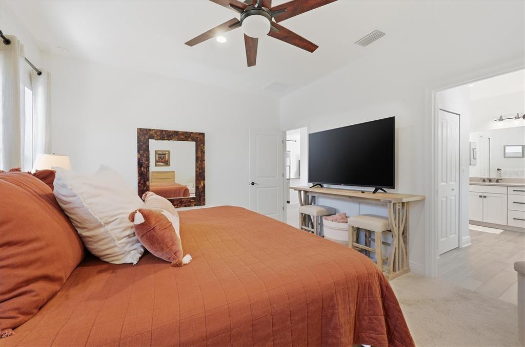 216 Brienza Loop Nokomis, FL 34275 - Photo 19 of 58 a bedroom with a bed and a flat screen tv on dresser