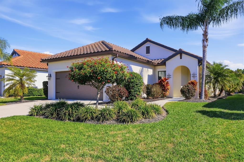 216 Brienza Loop Nokomis, FL 34275 - Photo 3 of 58 a front view of house with a garden