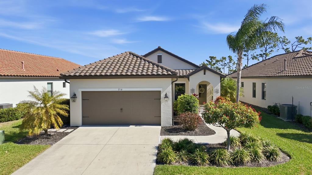 216 Brienza Loop Nokomis, FL 34275 - Photo 4 of 58 a front view of a house with garden