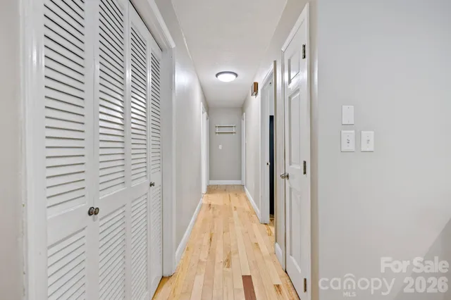 a view of a hallway with wooden floor and staircase