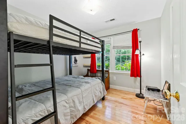 a bedroom with a bed and wooden floor