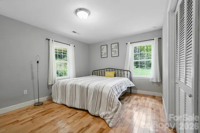 a bedroom with a bed and wooden floor