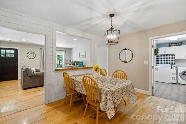 a view of dining room and livingroom with furniture wooden floor mirror and a chandelier