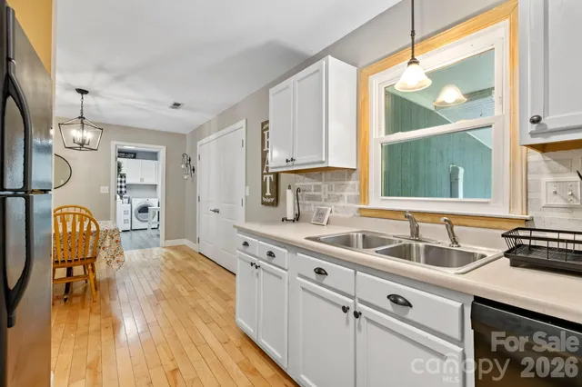 a kitchen with wooden cabinets a sink a window and breakfast area