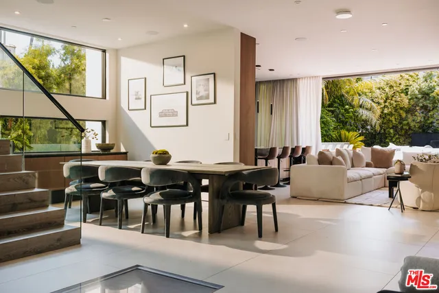 a living room with couches a coffee table and a large window with garden view