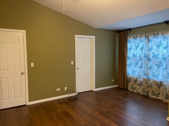 an empty room with wooden floor and closet area