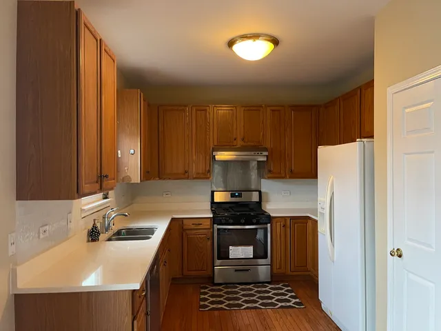 a kitchen with a sink a stove and a refrigerator