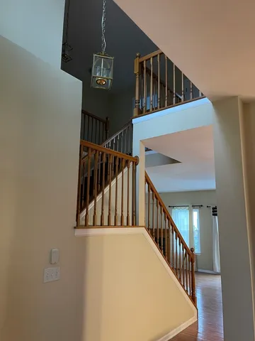 a view of staircase with railing and white walls