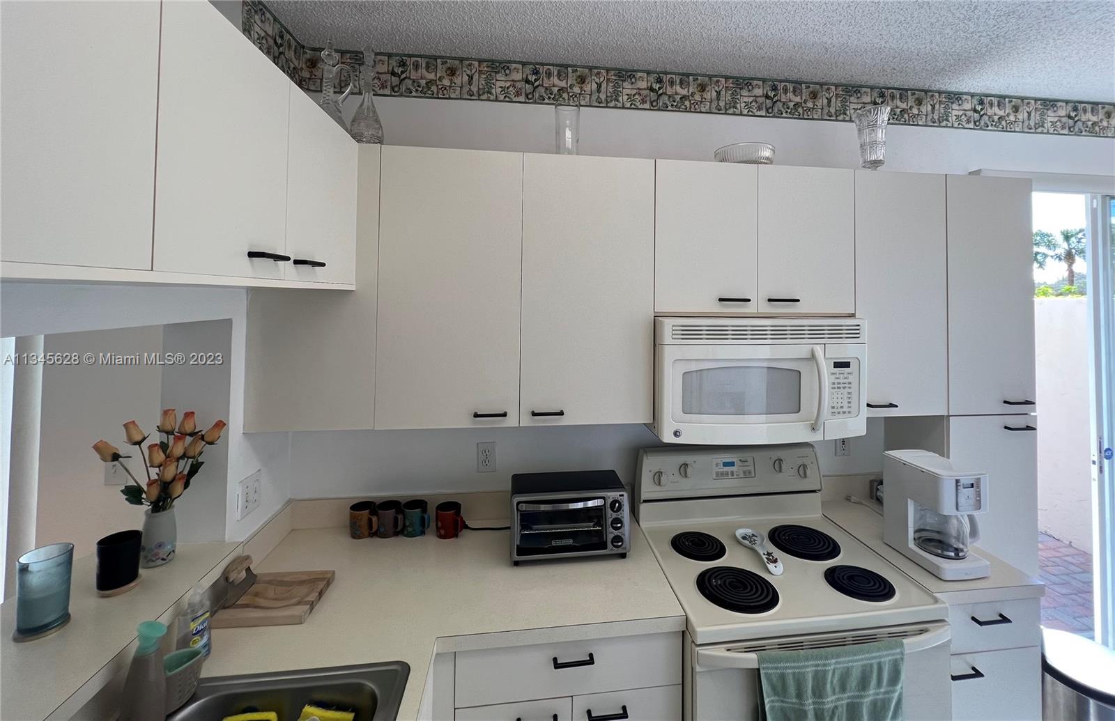 Towngate Pembroke Pines, FL 33028 - Photo 25 of 31 a kitchen with a stove a microwave and cabinets