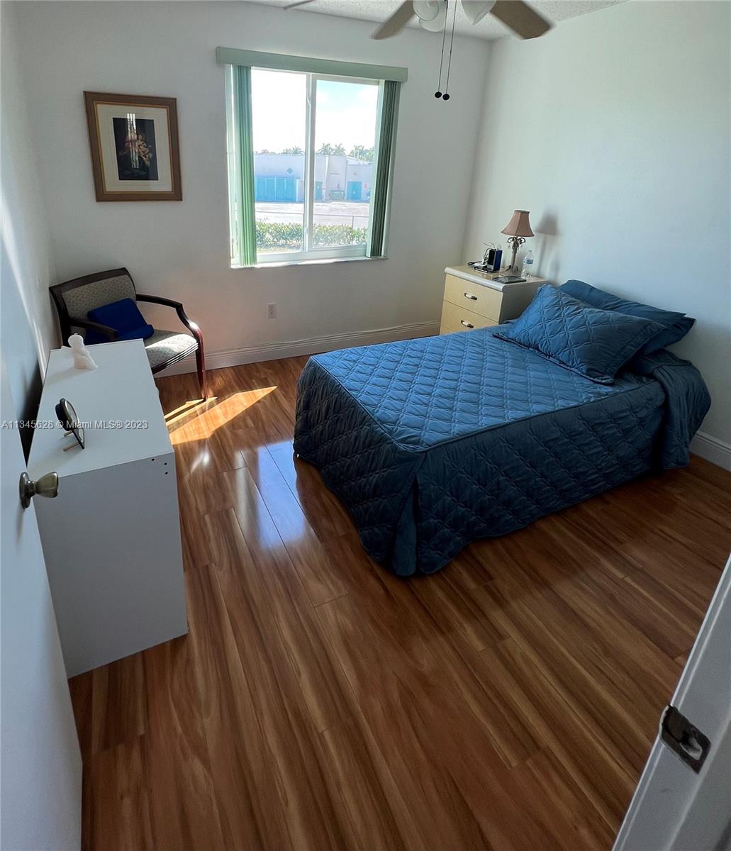 Towngate Pembroke Pines, FL 33028 - Photo 10 of 31 a bedroom with a bed and wooden floor