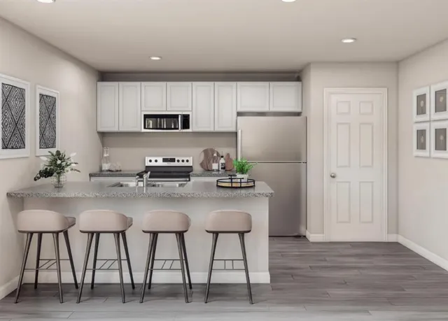a kitchen with stainless steel appliances white cabinets and chairs