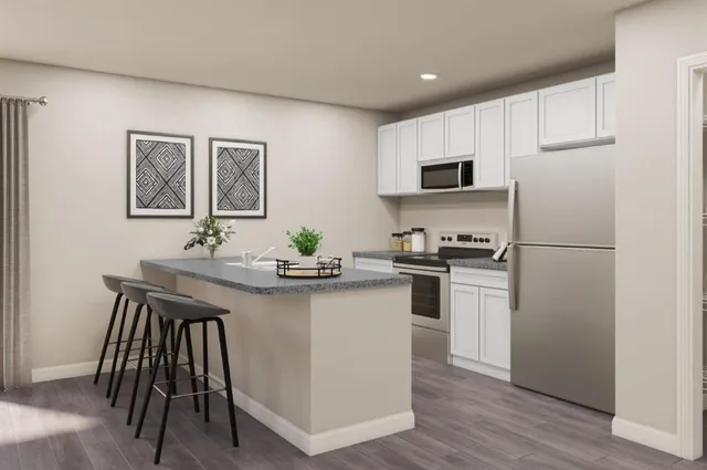 a kitchen with a refrigerator and a stove top oven