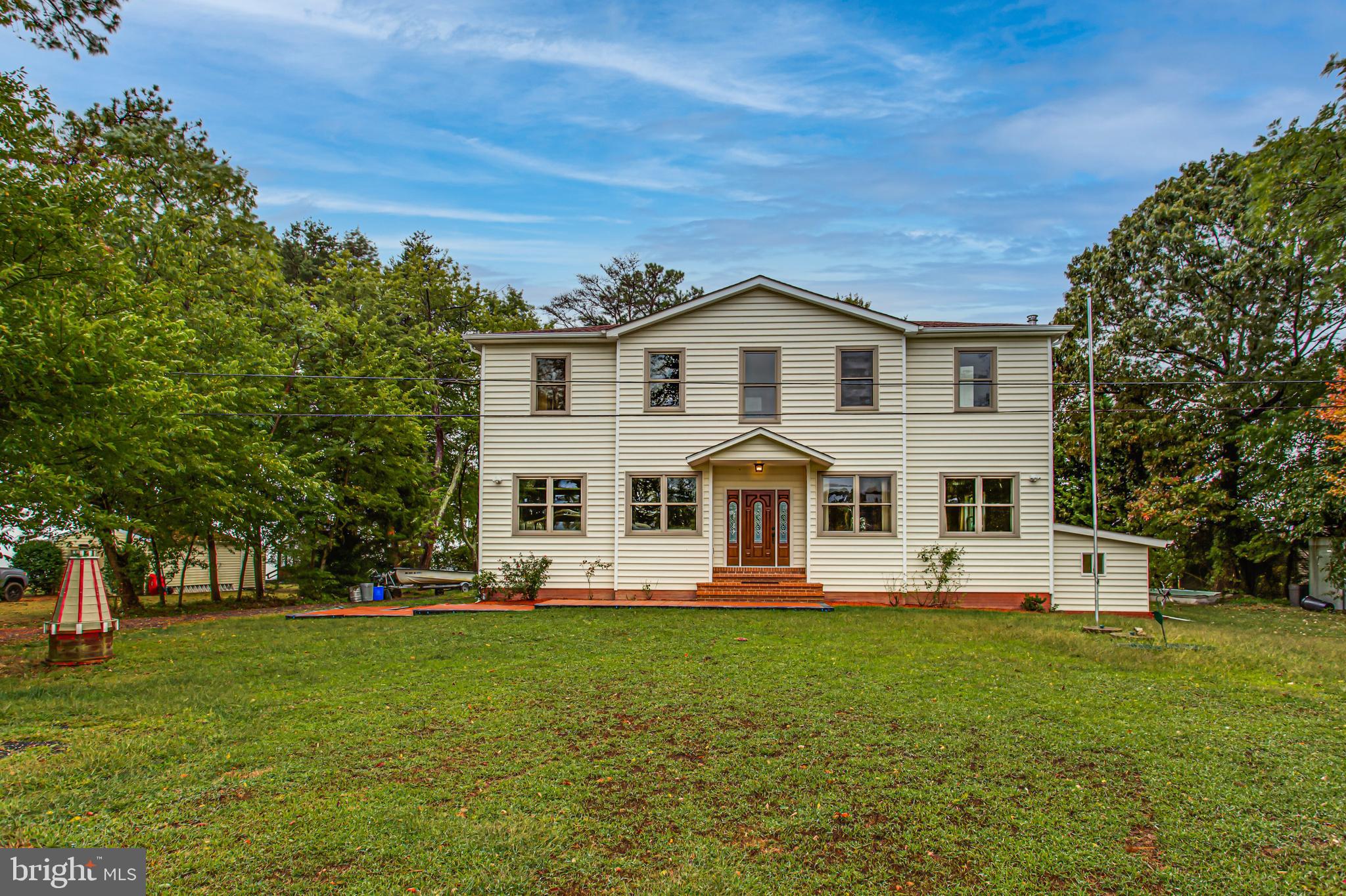 a front view of a house with a garden and trees