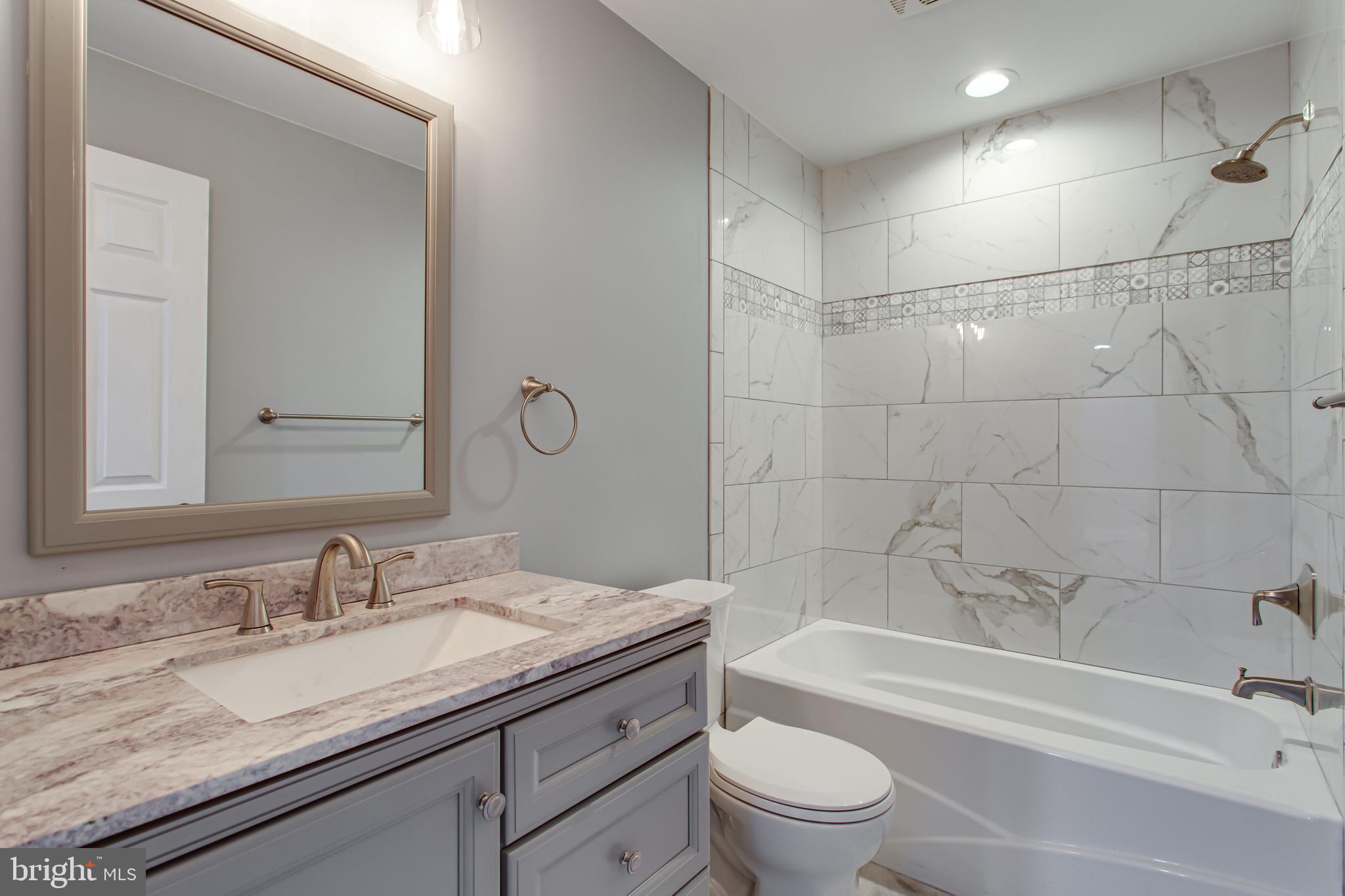 43840 Tarrywyle Way Leonardtown, MD 20650 - Photo 38 of 41 a bathroom with a granite countertop sink a toilet and bathtub