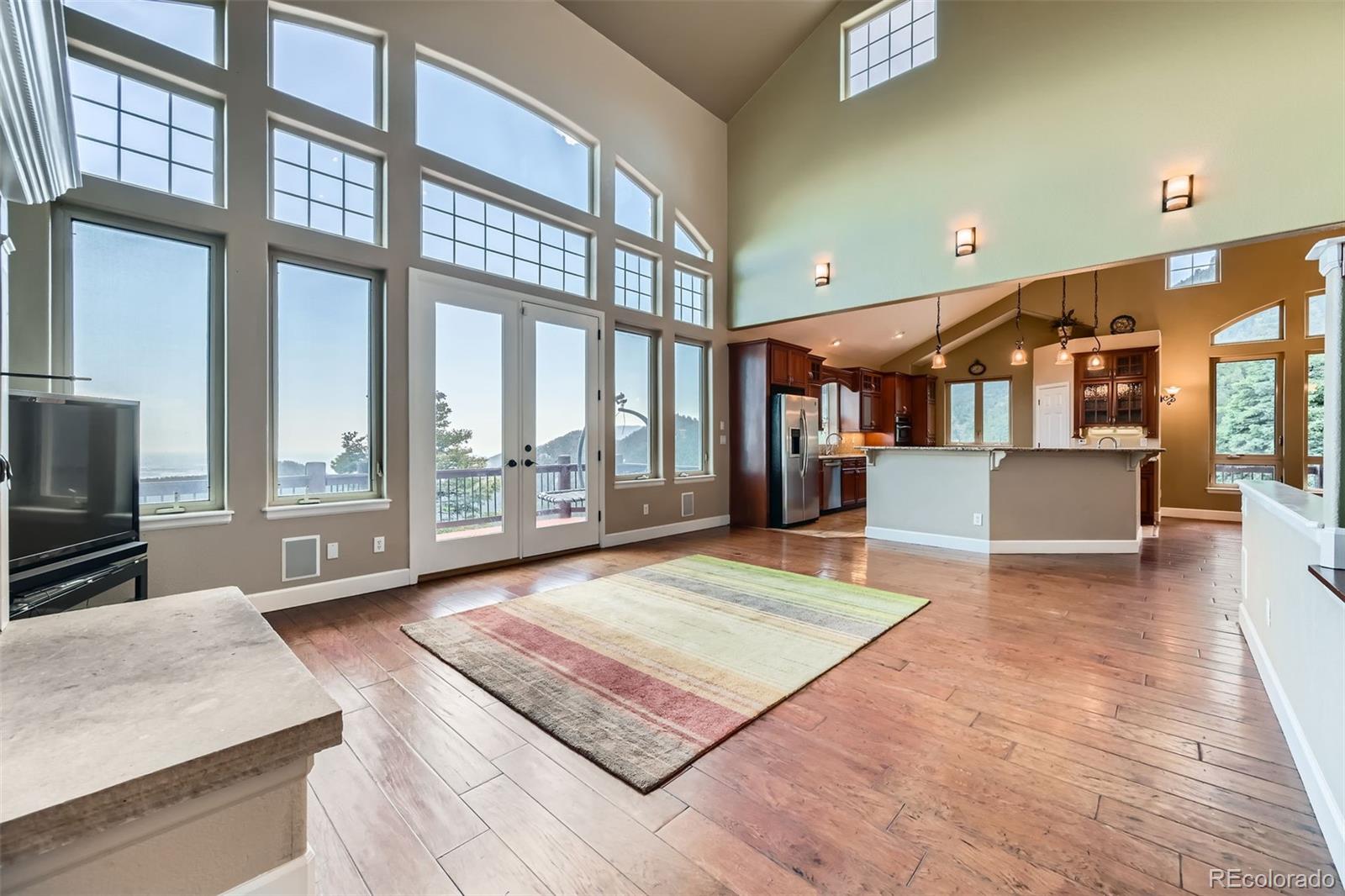 570 Upper Vista Road Manitou Springs, CO 80829 - Photo 15 of 36 a living room with large window and a wooden floor
