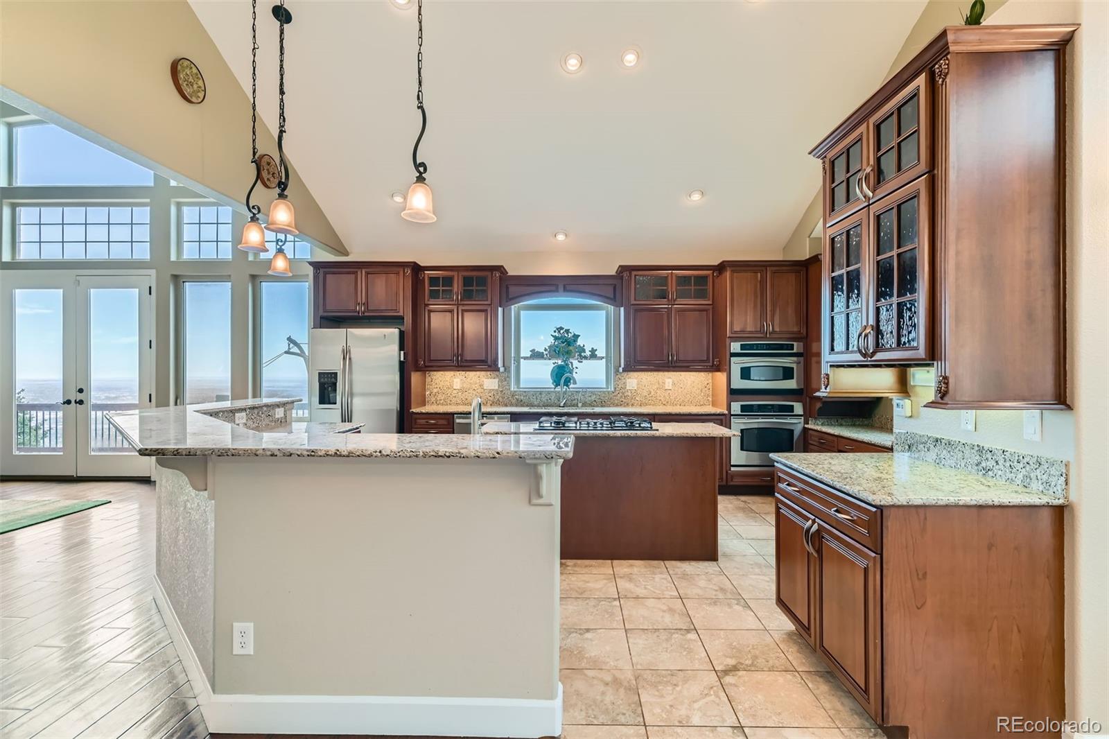 570 Upper Vista Road Manitou Springs, CO 80829 - Photo 19 of 36 a kitchen with stainless steel appliances granite countertop a sink a stove and a refrigerator