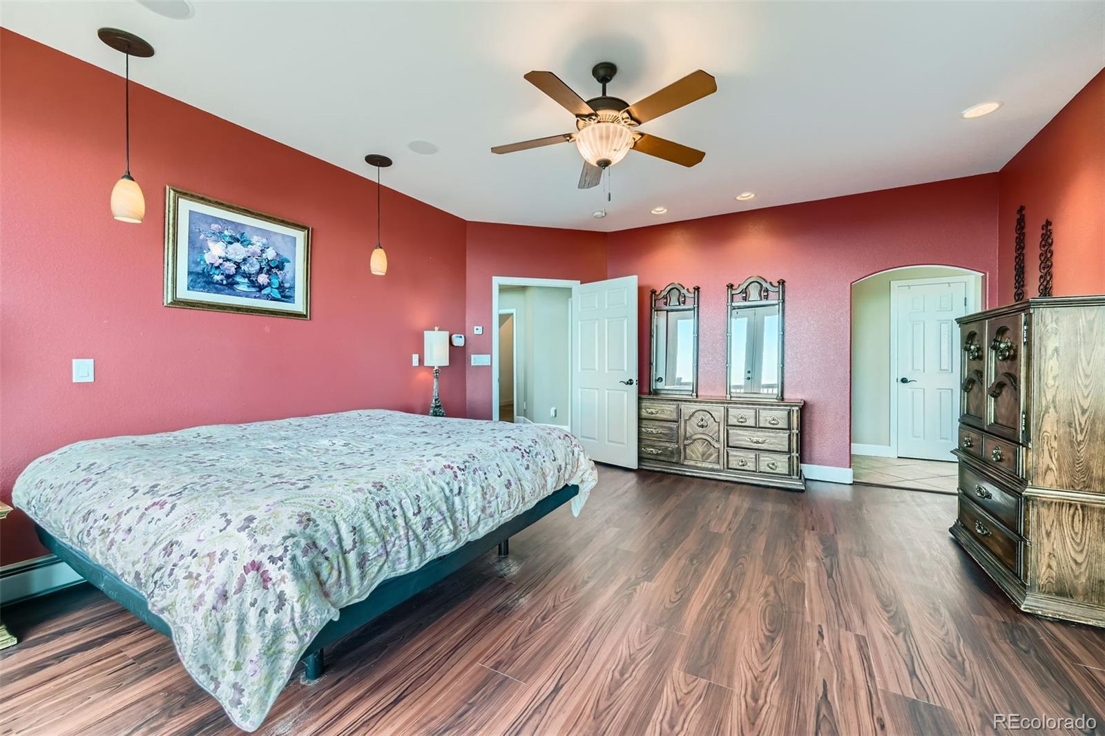 570 Upper Vista Road Manitou Springs, CO 80829 - Photo 22 of 36 a spacious bedroom with a bed and a chandelier