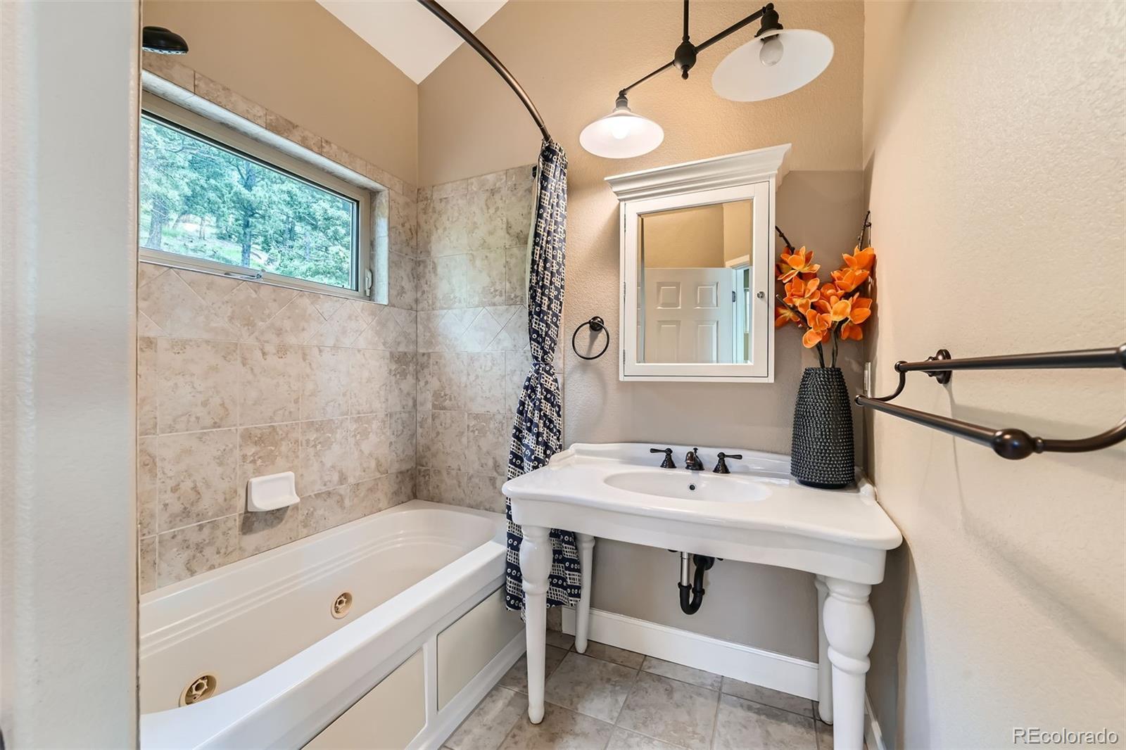 570 Upper Vista Road Manitou Springs, CO 80829 - Photo 28 of 36 a bathroom with a tub sink and mirror