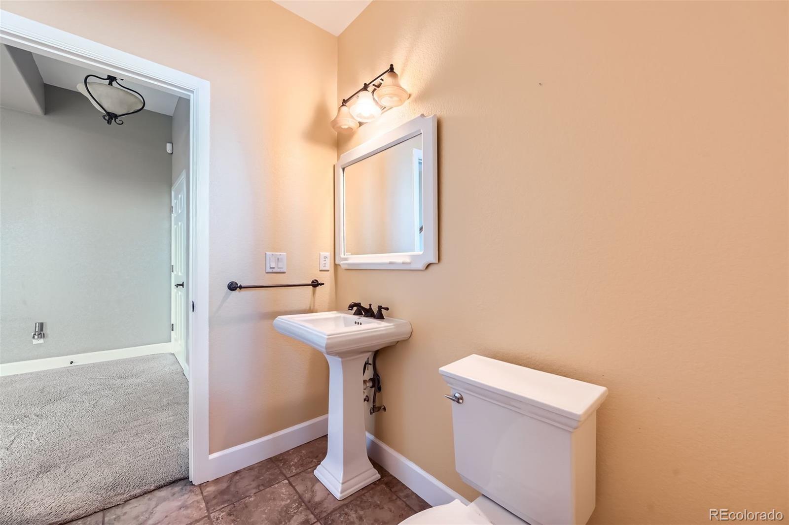 570 Upper Vista Road Manitou Springs, CO 80829 - Photo 32 of 36 a bathroom with a sink a toilet and mirror