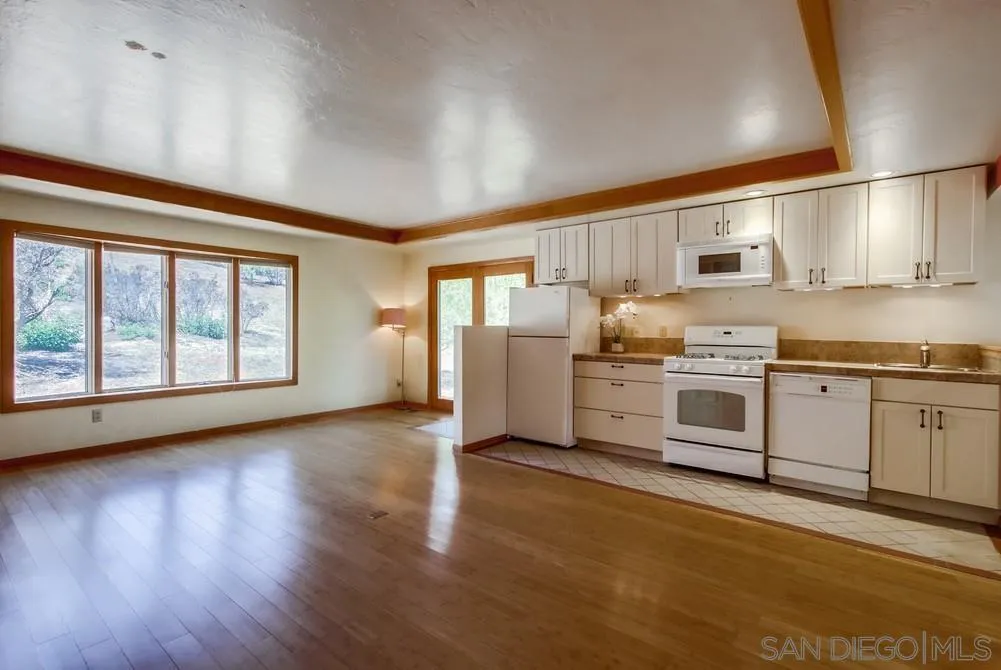 13595 Del Poniente Road Poway, CA 92064 - Photo 54 of 75 a kitchen with stainless steel appliances granite countertop a stove top oven a sink dishwasher and white cabinets with wooden floor