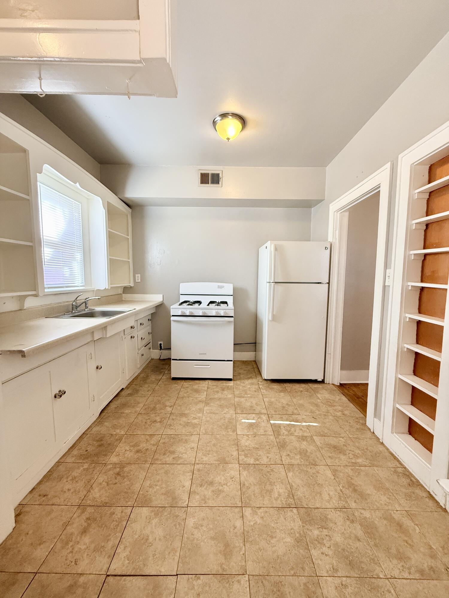 2105 14th Street, Unit 2 Lubbock, TX 79401 - Photo 11 of 15 a kitchen with a stove a sink and a refrigerator