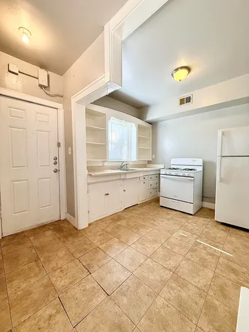 a view of a kitchen with a sink and a refrigerator