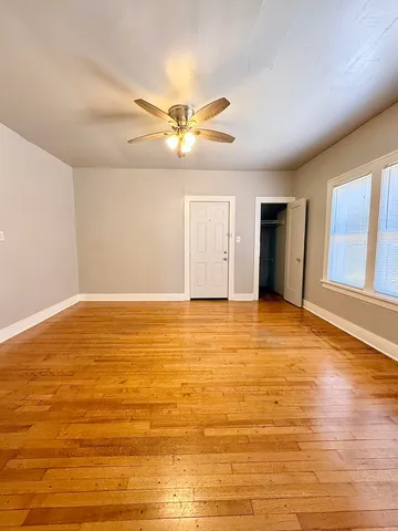 a view of an empty room with window and a ceiling fan
