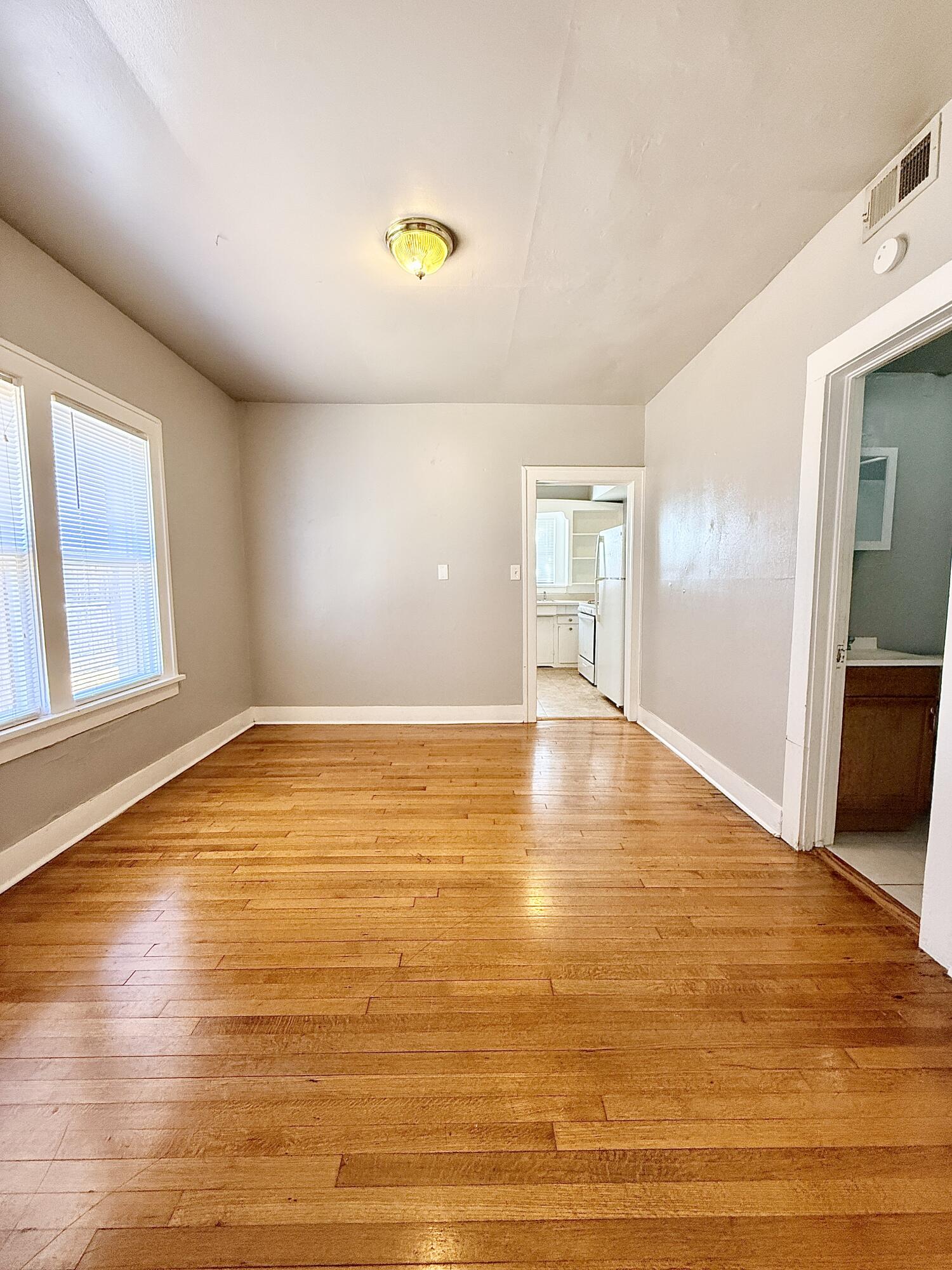 2105 14th Street, Unit 2 Lubbock, TX 79401 - Photo 7 of 15 a view of empty room with wooden floor and seating space