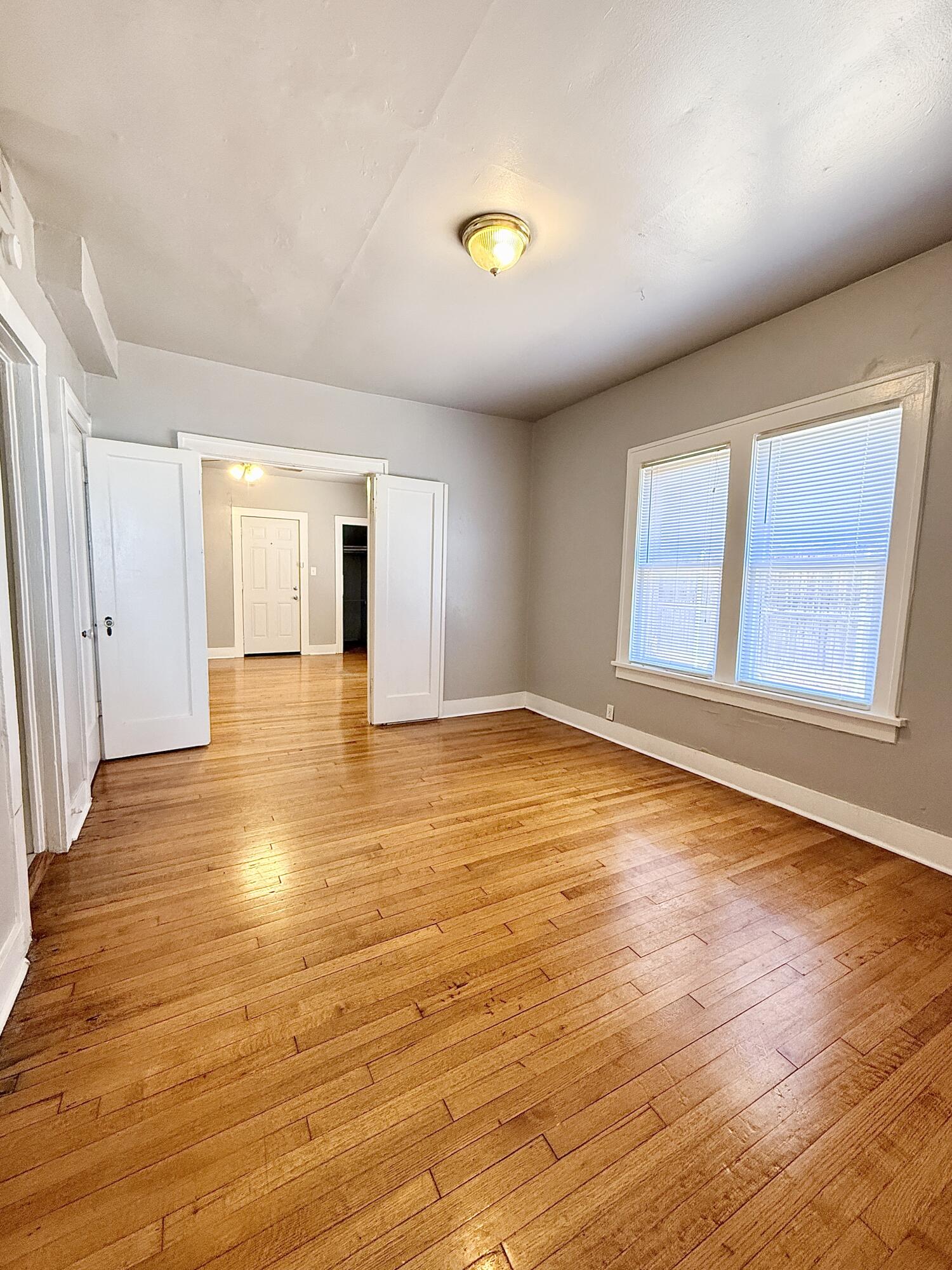 2105 14th Street, Unit 2 Lubbock, TX 79401 - Photo 8 of 15 wooden floor in an empty room with a window