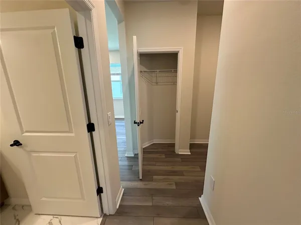 a view of an empty room with wooden floor and closet