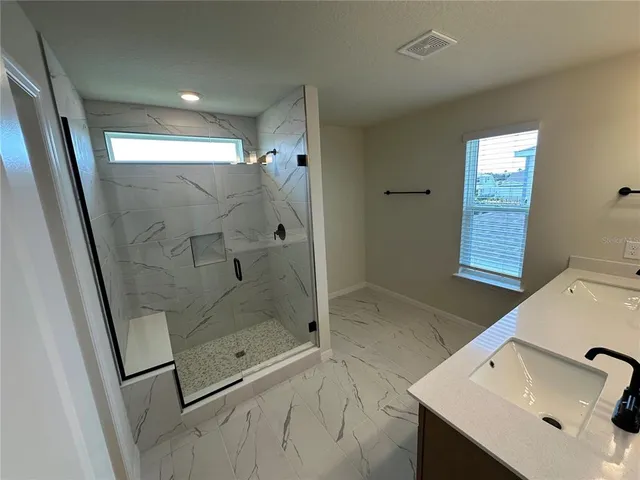 a bathroom with a granite countertop sink toilet and shower curtains