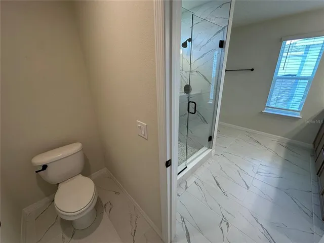 a bathroom with a sink a toilet a mirror a vanity and bathtub