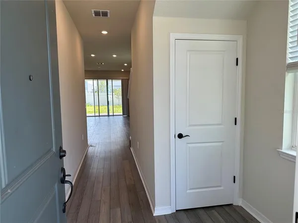 wooden floor with windows and chandelier