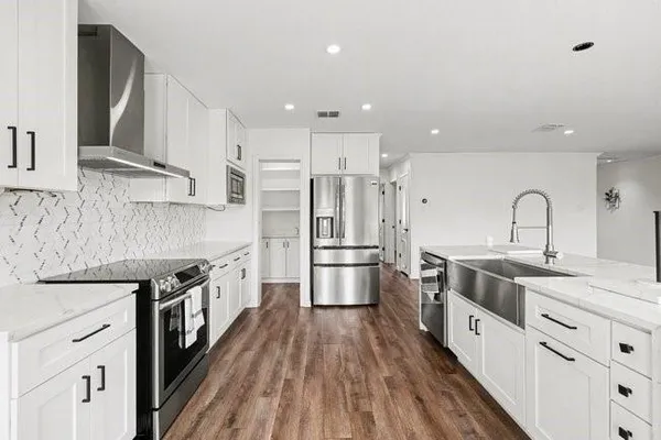 a kitchen with stainless steel appliances a stove a sink and a refrigerator