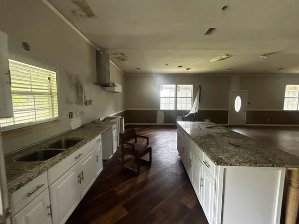 a large kitchen with granite countertop a sink and stove top oven