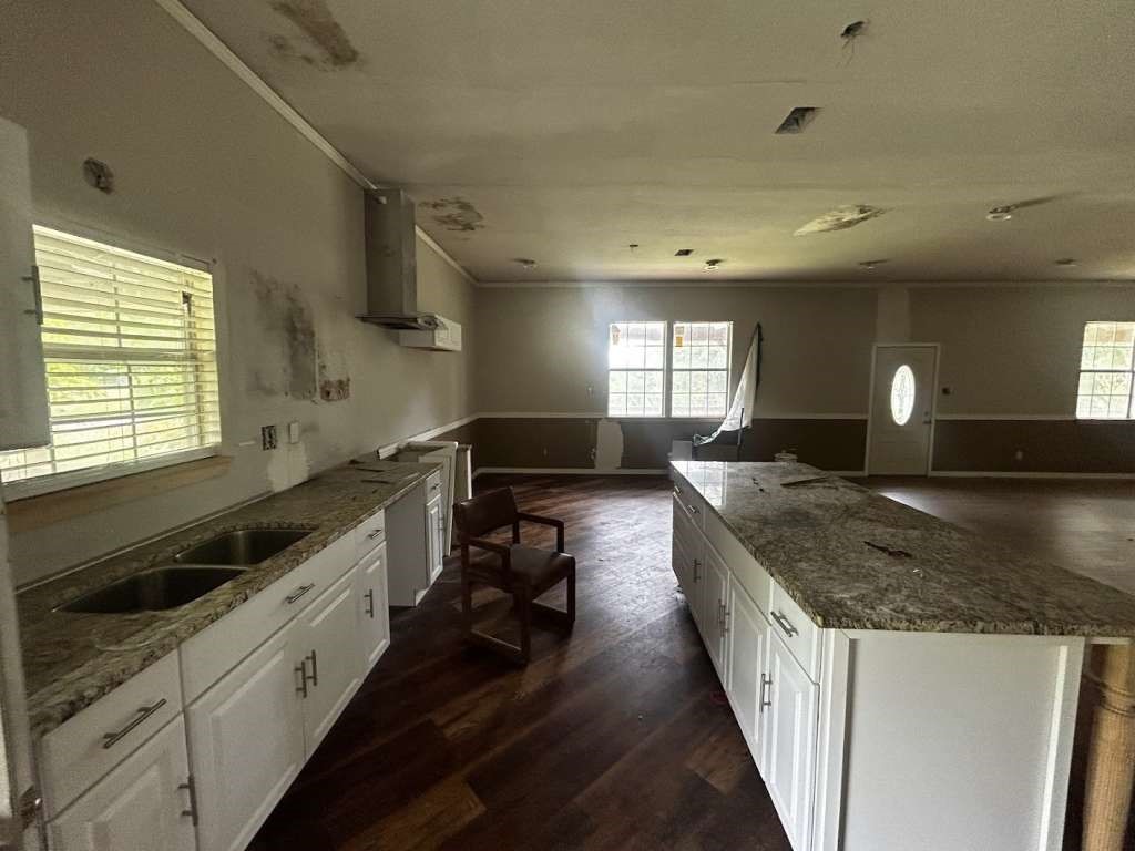 206 Grayson Street Teague, TX 75860 - Photo 2 of 9 a large kitchen with granite countertop a sink and stove top oven