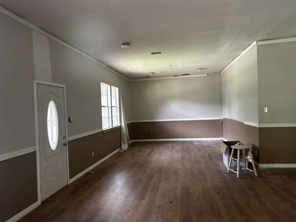 206 Grayson Street Teague, TX 75860 - Photo 3 of 9 an empty room with wooden floor and windows