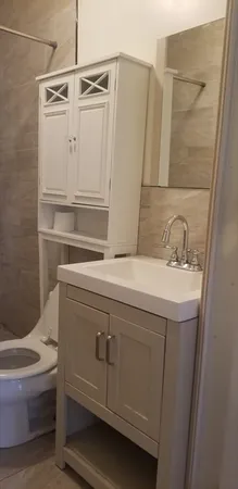 a bathroom with a sink a toilet and shower