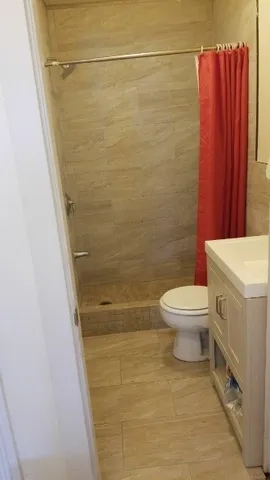 a bathroom with a toilet and a shower