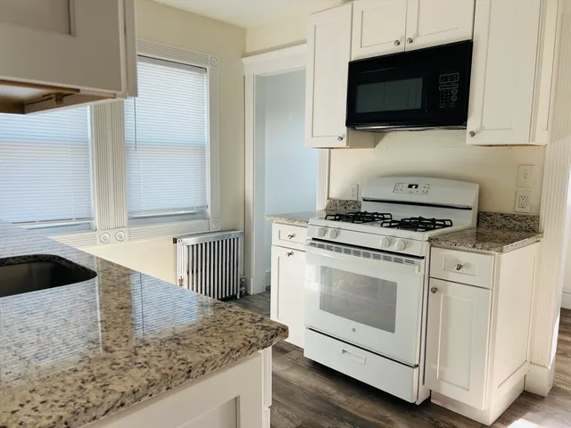 a kitchen with granite countertop a sink and a stove top oven